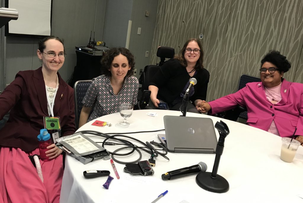 Four presenters seated around a conference table